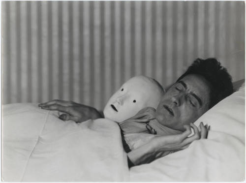 Jean Cocteau in Bed with Mask (1927) by Berenice Abbott.jpg